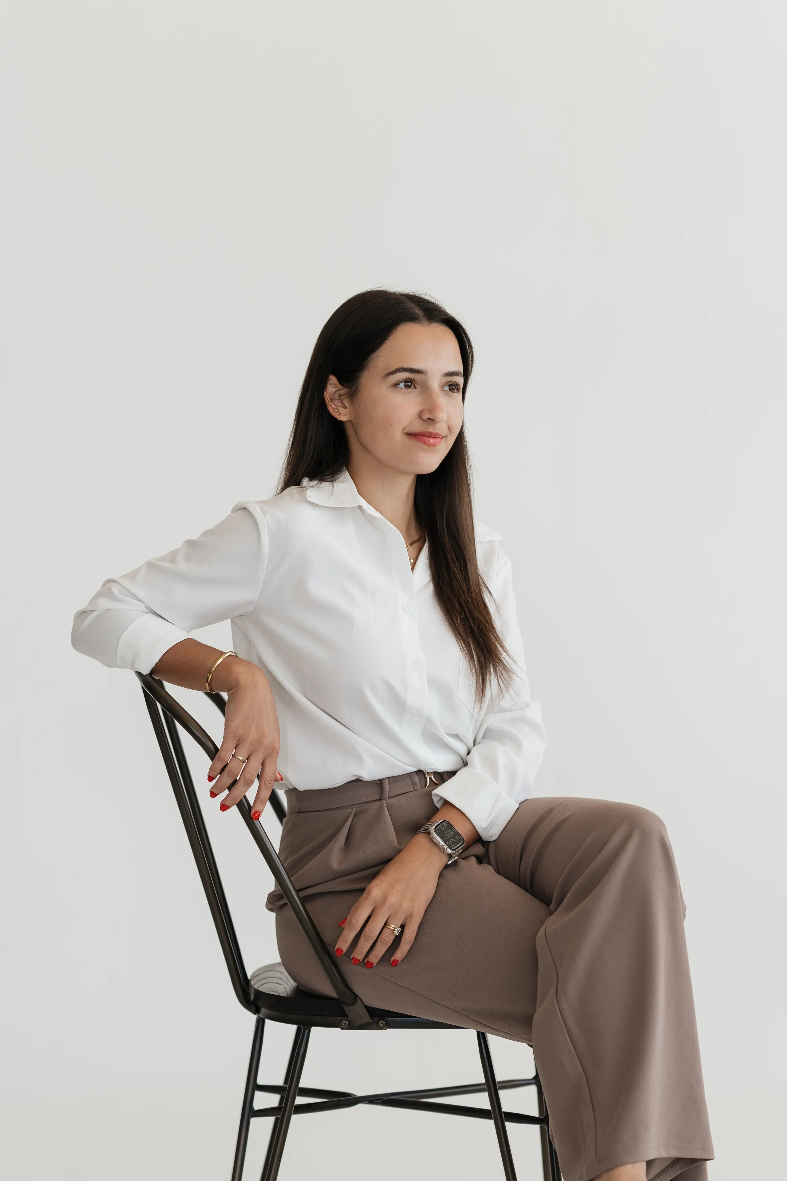 Jena de Leeuw, owner and lead photographer, seated studio portrait in a white shirt