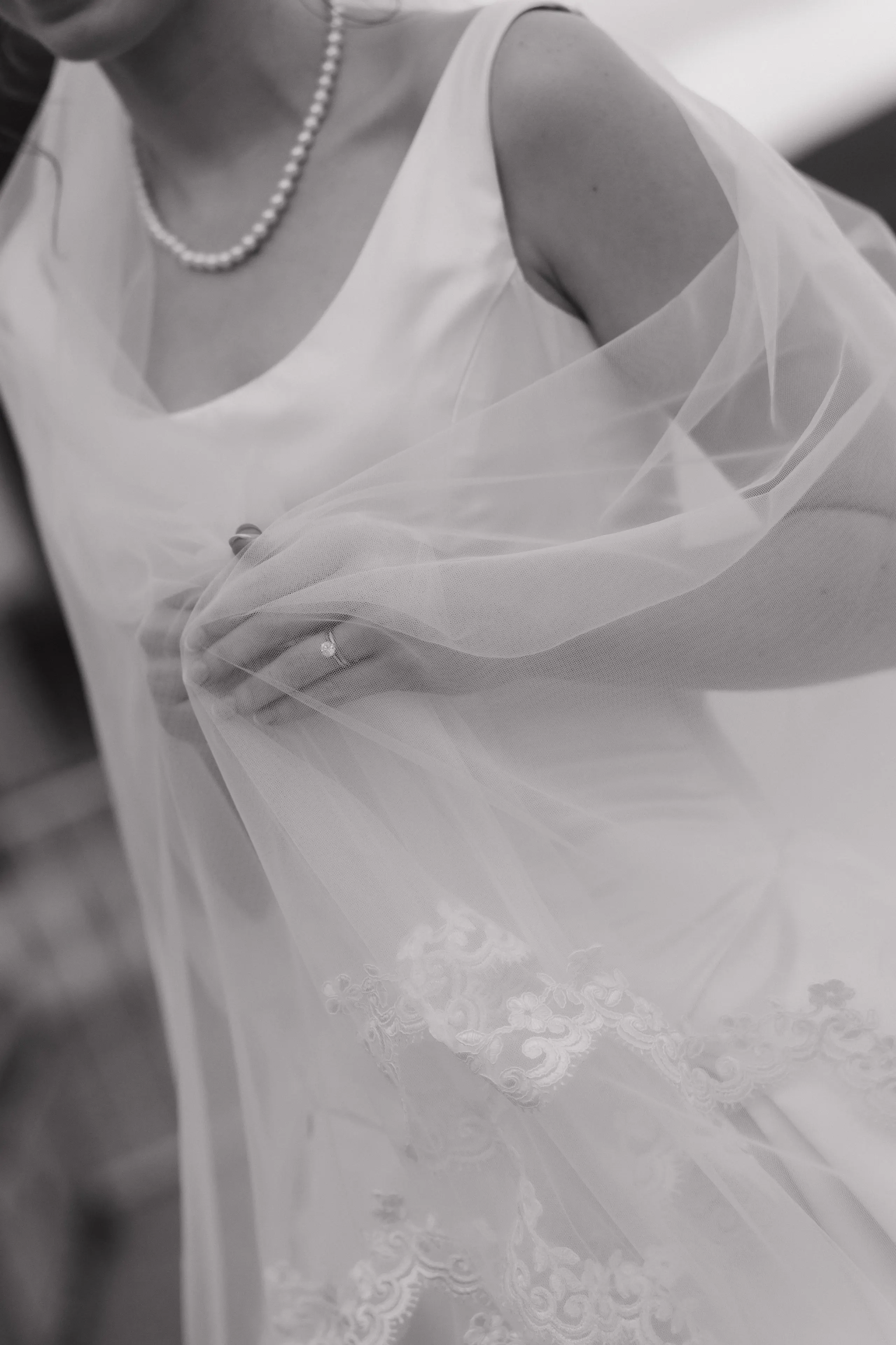 Soft detail of the bride's hands beneath her veil