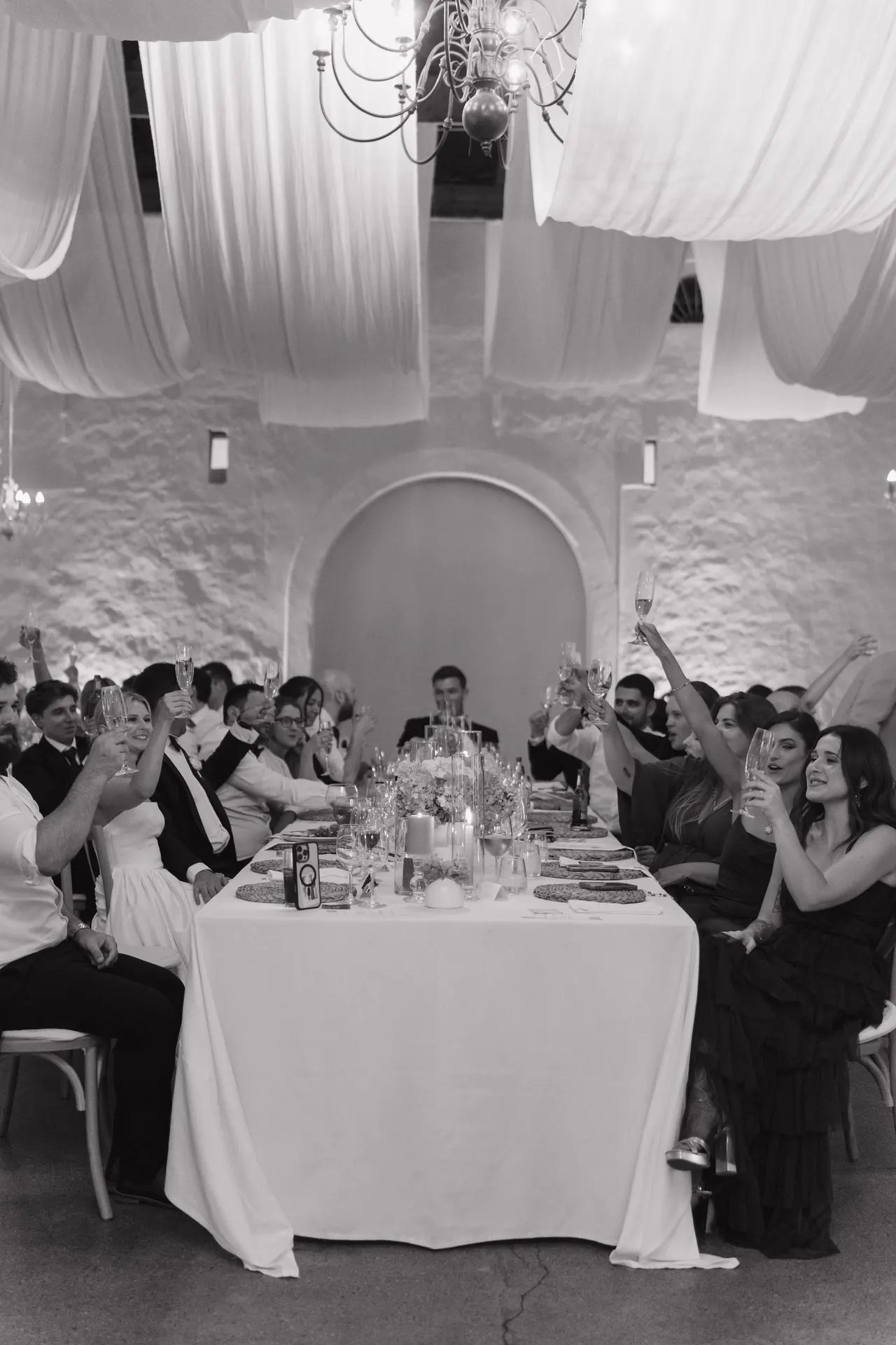 Black-and-white reception moment — guests raising a toast at Mark & Amy's wedding