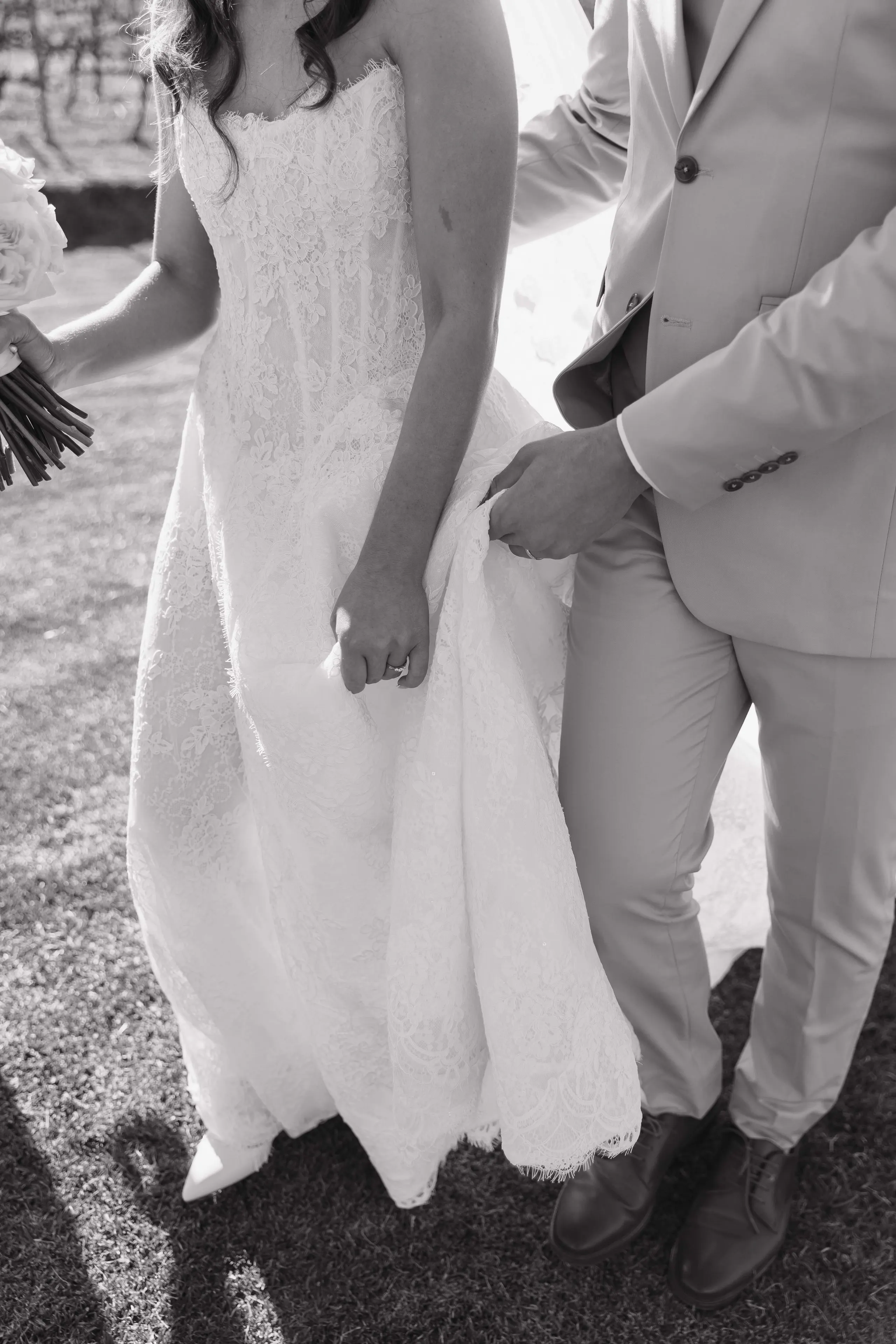 Black-and-white detail of the couple's hands clasped together